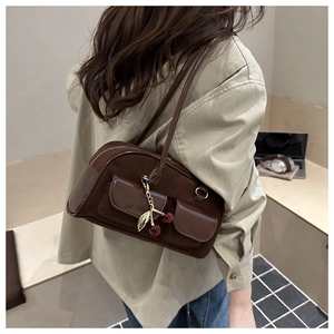 Detail of vintage brown Boston bag with cherry charm shown on model's shoulder