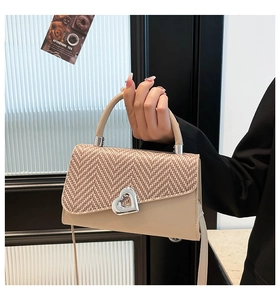 Dettaglio della borsa a tracolla in tweed con chiusura a girello argentata a cuore