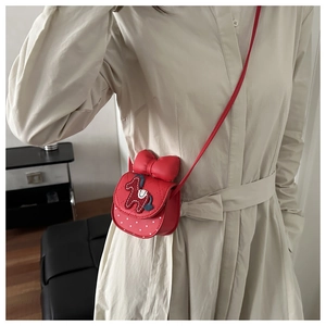 Dettaglio borsa a tracolla trapuntata rossa con fiocco 3D, toppa pony e piccoli cuori