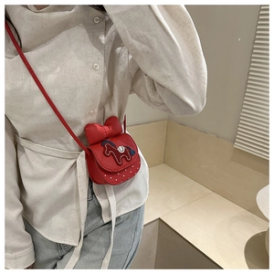 Dettaglio mini borsa a tracolla rossa con ricamo a forma di pony e un grande fiocco
