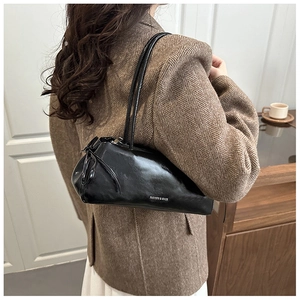 Dettaglio borsa sottobraccio in pelle nera lucida con scritta Fashion & Bags bianca