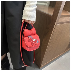 Dettaglio della borsa a tracolla rossa con cavallo, fiocco e cuori per bambine