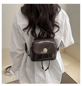 Deep brown faux leather mini backpack with a metallic twist lock and drawstring details
