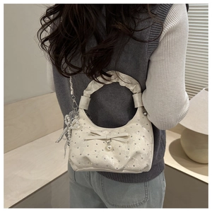 Dettaglio borsa in tessuto bianco con fiocco di perle e manico plissettato