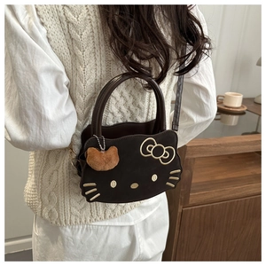 Detailed embroidery of cat face on a dark brown PU leather crossbody bag with plush ball