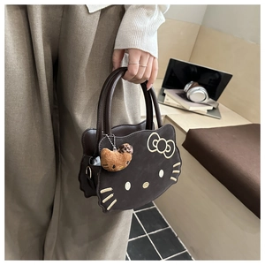 Detailed embroidery on a brown cat-shaped handbag with a plush charm and sturdy handle