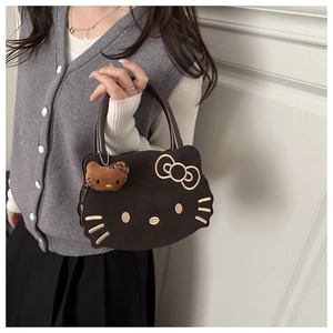 Detail of cute cat embroidery on a brown plush handbag with matching plush pendant charm