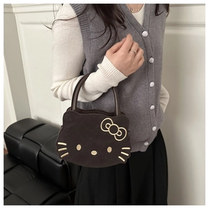Detail of Hello Kitty shaped brown handbag with golden embroidery and suede texture