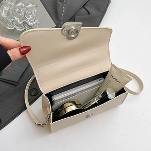 Borsa a tracolla beige con fibbia a cuore che mostra l'ampio interno per oggetti