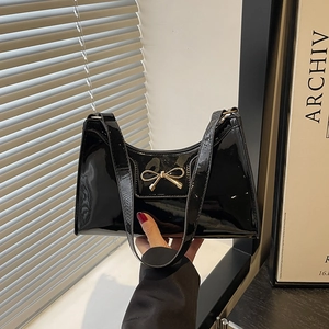 Elegante borsa a spalla baguette in vernice nera con fiocco dorato e tracolla sottile