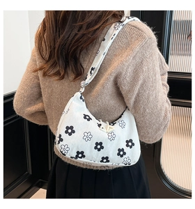 Dettaglio borsa hobo in velluto a coste bianco con stampa a margherita sulla spalla