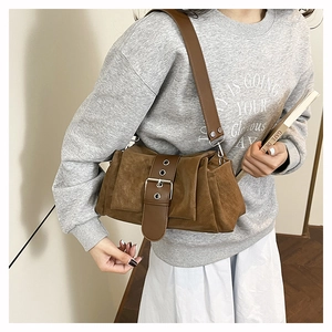 Vue détaillée d'un sac à bandoulière vintage marron en daim avec boucle décorative