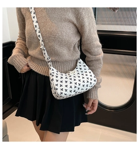 Borsa a tracolla bianca a mezzaluna con stampa di fiocchi neri indossata da modella