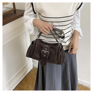 Detail of dark brown faux suede handbag featuring retro belt buckle and metal eyelets