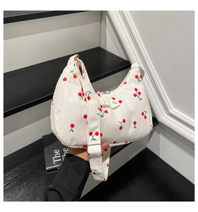 Dettaglio borsa hobo in velluto a coste con stampe di ciliegie e tracolla regolabile