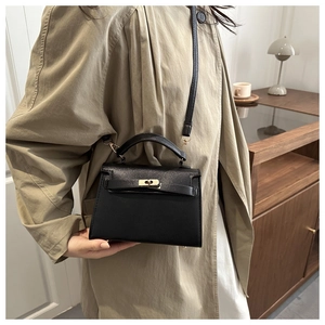 Detailed view of a black Saffiano leather crossbody bag with golden twist lock and strap