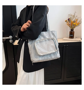 Detalle del bolso tote de nailon azul claro con bolsillo de malla blanco y tejido arrugado