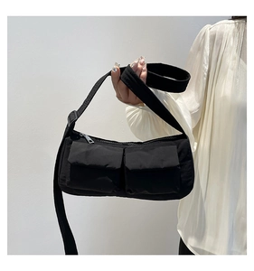 Dettaglio della borsa a tracolla in nylon nero con due tasche frontali a patta e tracolla larga