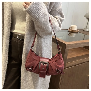 Dettaglio della borsa a spalla in camoscio rosso con fibbia in metallo e stile vintage