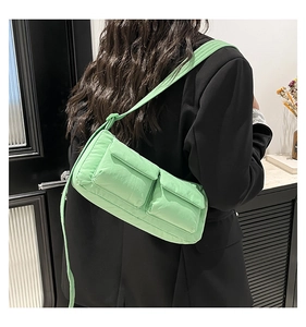 Vista dettagliata della borsa a tracolla trapuntata verde menta con tasche a patta