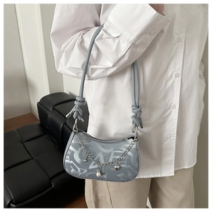 Detail of grey crescent hobo bag with silver chain, star pendants and knotted strap