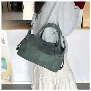 Dettaglio della borsa tote in pelle verde scuro con tasche a zip e tracolla regolabile