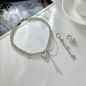 Choker di perline argentate con ciondoli a cuore e stella e set di orecchini nappa