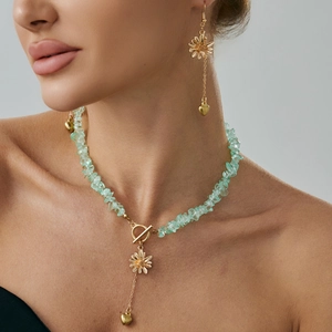 Set collana e orecchini con pietre verdi, fiori dorati e ciondoli a cuore