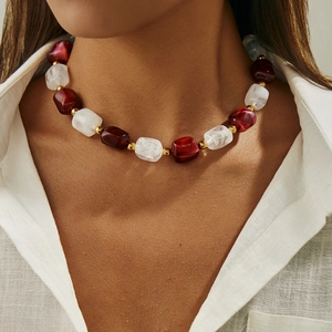 Dettaglio della collana vintage in resina con grandi pietre bordeaux e color crema