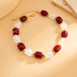 Dettaglio della collana con perle in resina irregolari e distanziatori metallici dorati