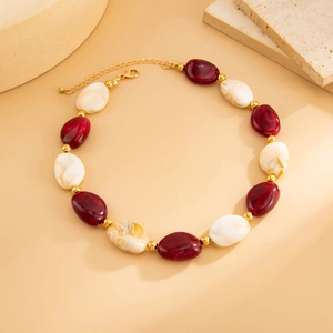 Dettaglio di collana di perle in resina colorata con distanziatori e chiusura oro