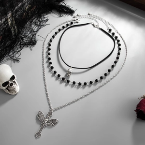 Detailed view of gothic three-piece layered necklace set with skull moth cross pendants