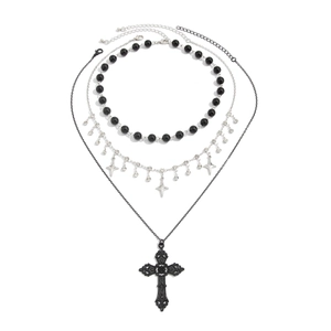 Gothic layered necklace set with silver cross and star pendants on a white background