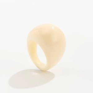 Dettaglio di un anello spesso in resina bianco crema con finitura lucida e liscia
