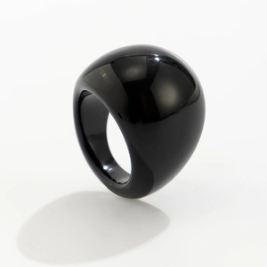 Primo piano di un anello in acrilico nero lucido con un profilo liscio a cupola
