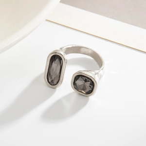 Détail d'une bague ouverte argentée avec pierres géométriques en acrylique noir facetté