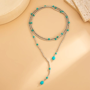 Detail van boho zilveren kralenketting met turquoise stenen en een druppel hanger