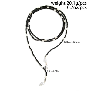 Detail van een 120 cm lange ketting met zwarte facetkralen en witte zoetwaterparels