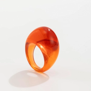 Detailansicht eines breiten, bernsteinfarbenen Harzrings mit hochglanzpoliertem Finish