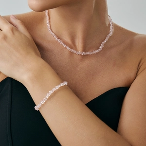 Set collana e bracciale con cristalli rosa e perle sfaccettate irregolari su modella