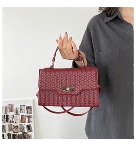 Detailansicht der weinroten Leder-Webtasche mit goldenem Drehverschluss am Gehäuse