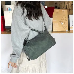 Dettaglio della borsa tote vintage verde scuro con tracolla regolabile al bar