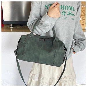 Dettaglio borsa vintage verde scuro opaco con manici robusti e tracolla regolabile