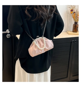 Detail of light pink pleated cloud bag with large pearl handle and silver chain strap