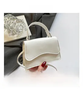Dettaglio della mini borsa bianca con patta a onde e trama in pelle PU liscia