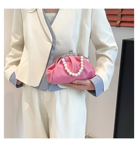 Detailed shot of coral pink cloud bag with pearl handle and vintage silver clasp