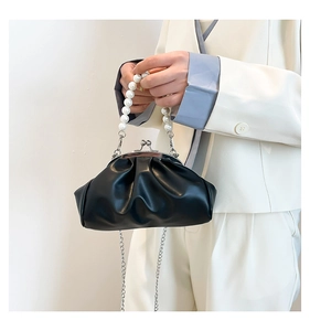 Detail of black pleated cloud bag with pearl handle and metal chain strap