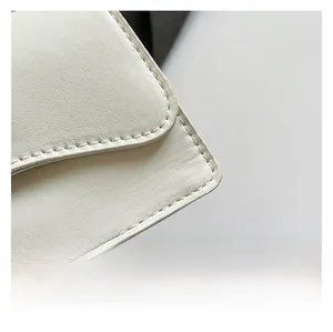 Vista macro di borsa in pelle bianca con cuciture premium e dettagli della trama fine