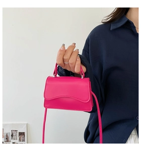 Dettaglio mini borsa fucsia con patta a onde e trama in pelle opaca di alta qualità