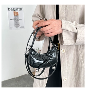 Dettaglio della borsa hobo in pelle nera stropicciata con fiocco e perle argentate